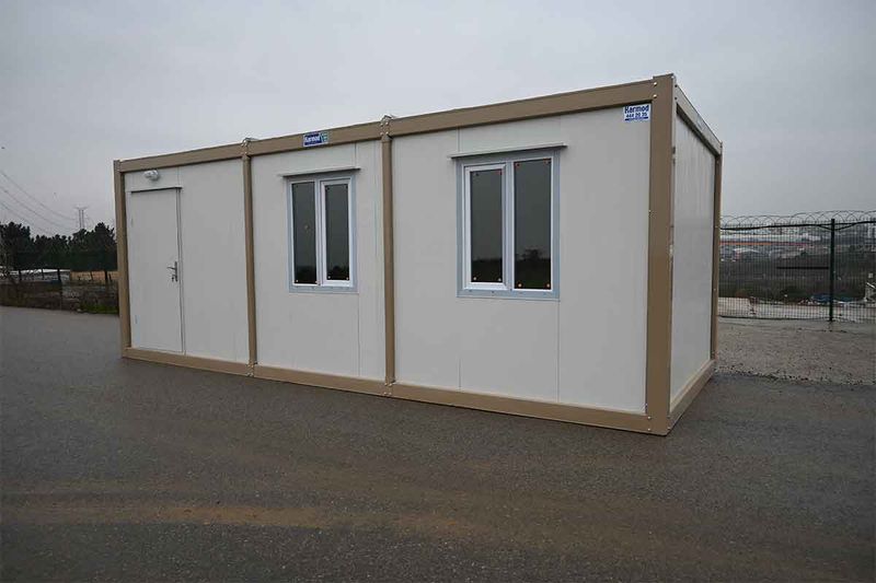 Rear three-quarter view of a standard container unit on a paved yard under an overcast sky.