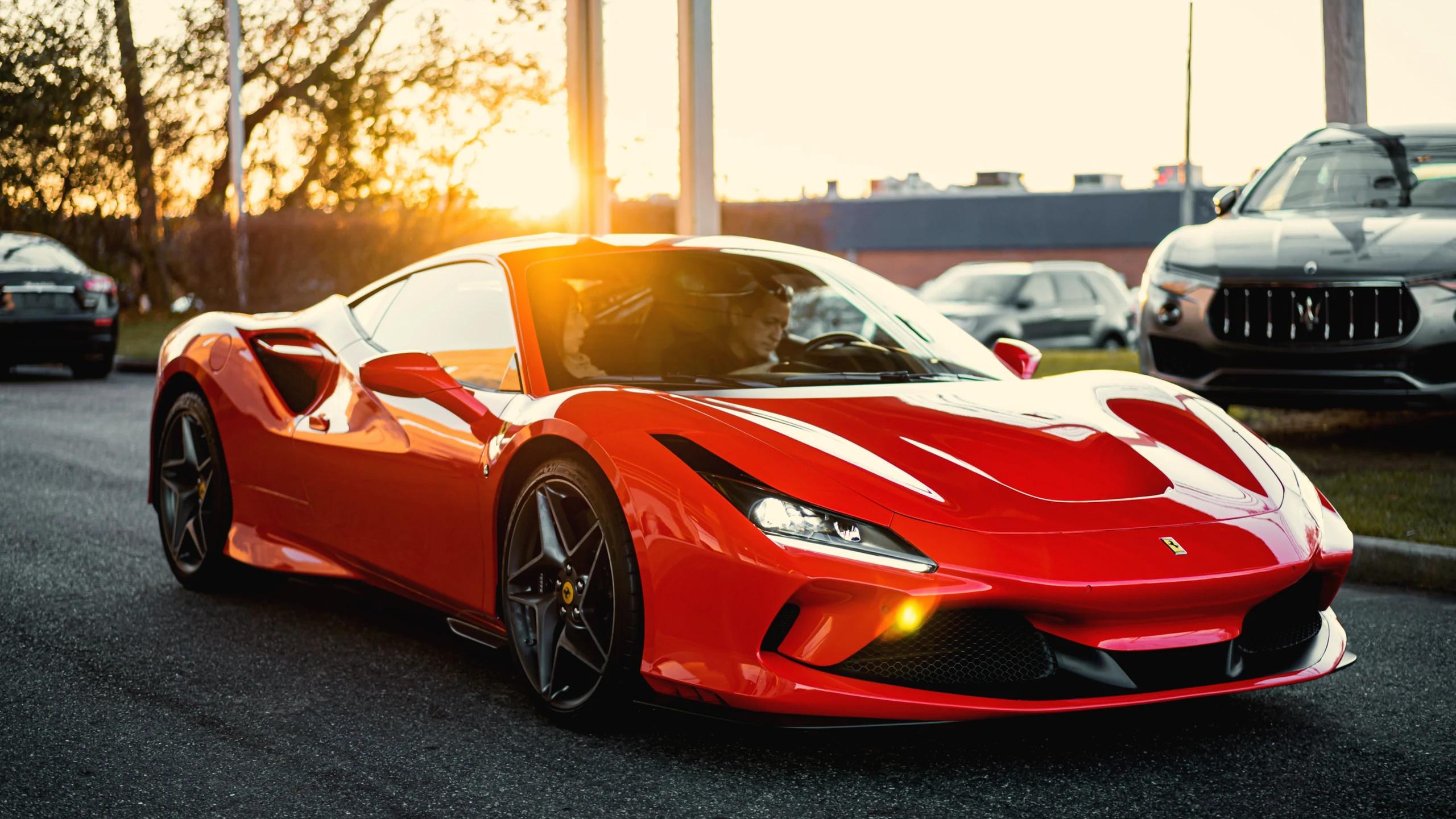 Glossy red finish panel of a sports car close-up with light reflection