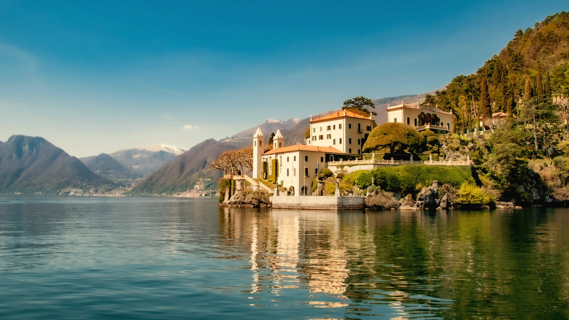 Lake Como at dawn with morning mist and historic villa on shoreline