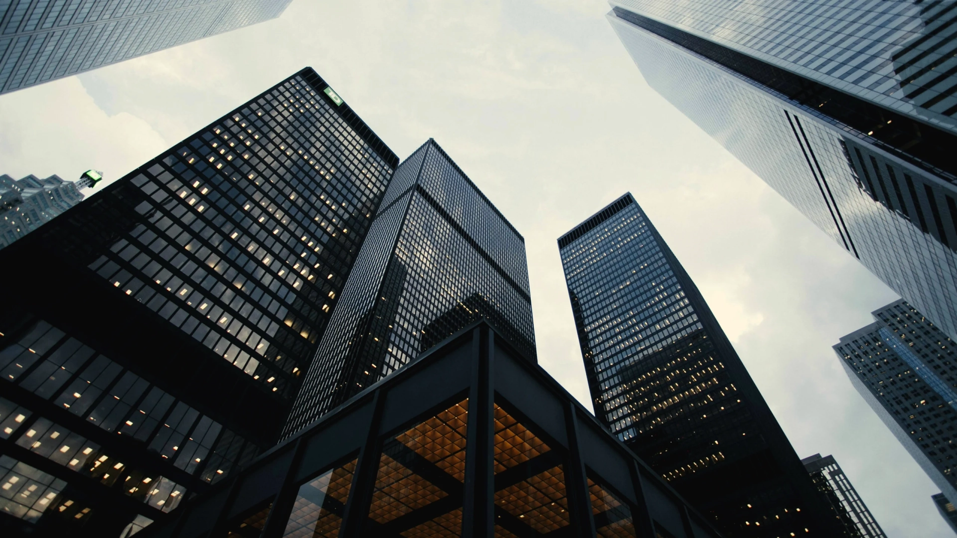 Modern architectural glass skyscraper reflecting clouds in bright daylight