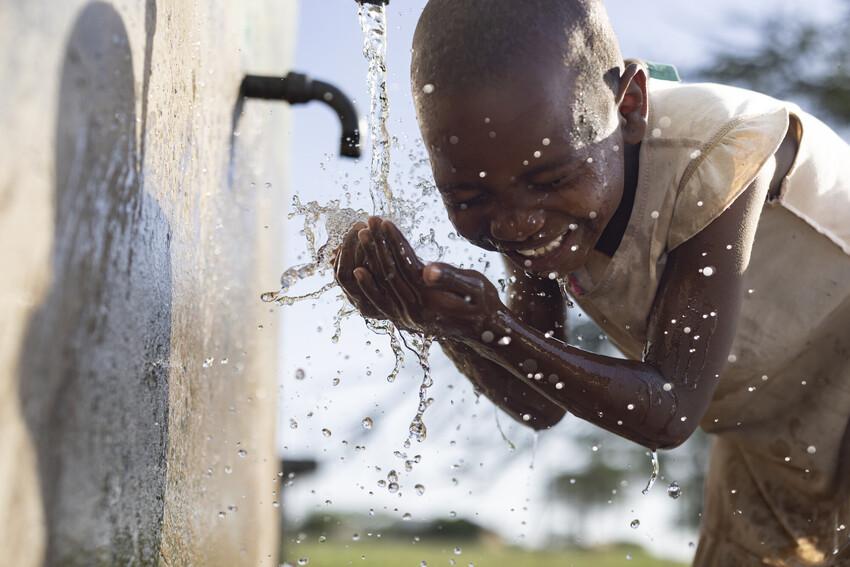 child washing face in Kenya