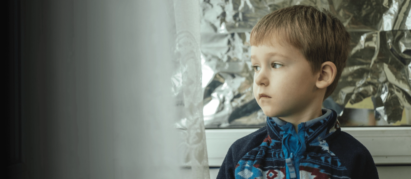ukrainian child standing by window