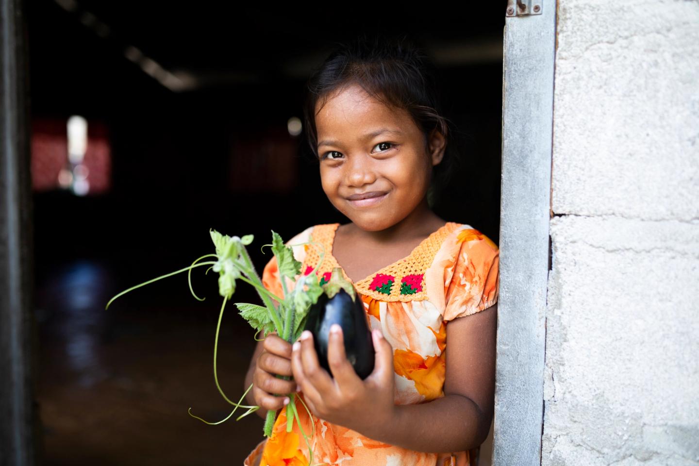 child holding vegetables in kiribati