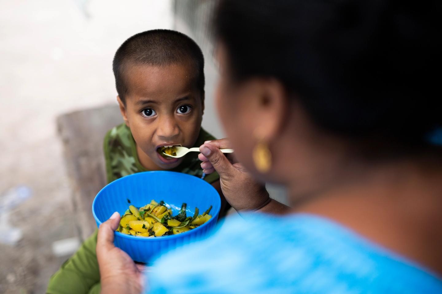 child being fed in kiribati
