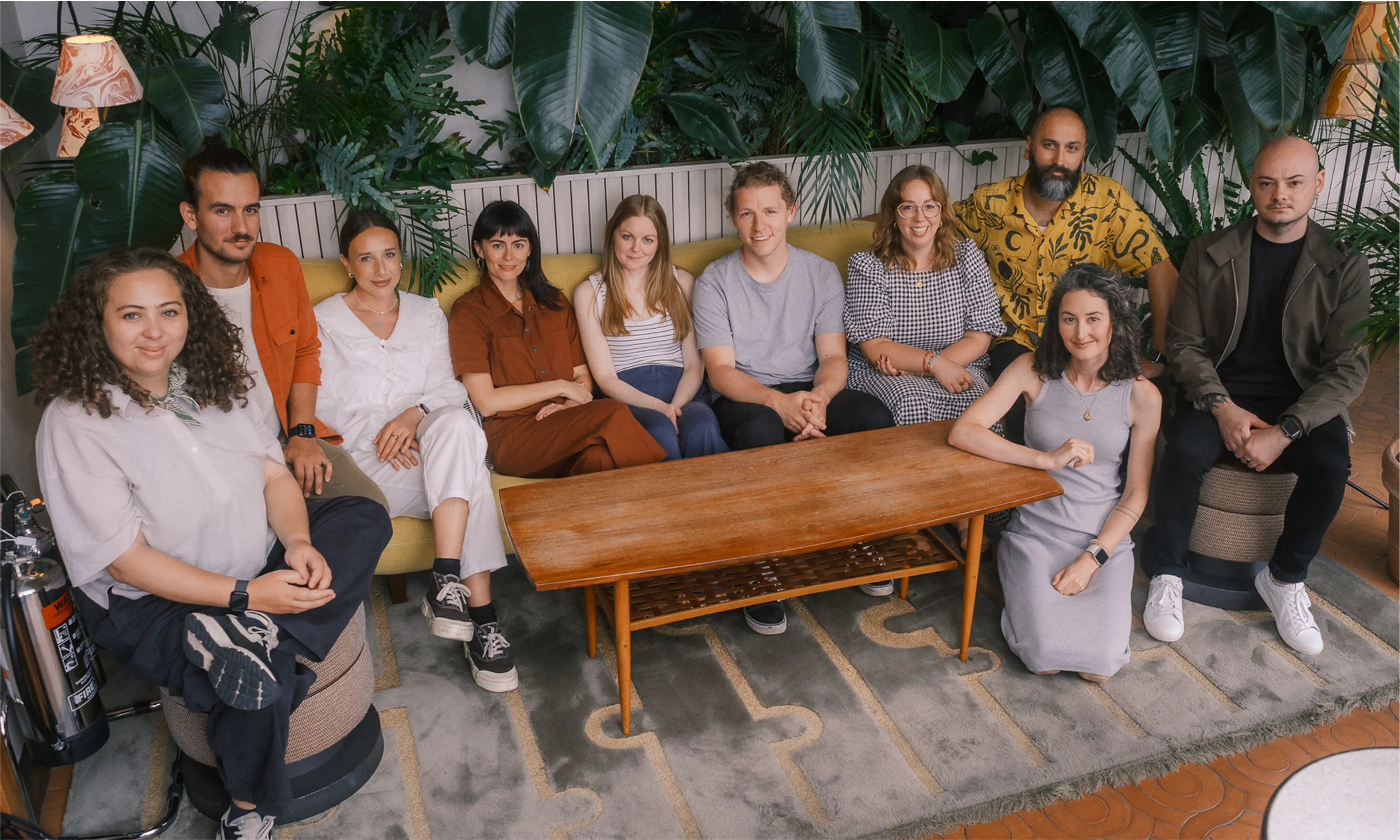 The entire Driftime team, sat in a comfortable space posing for a photo together.