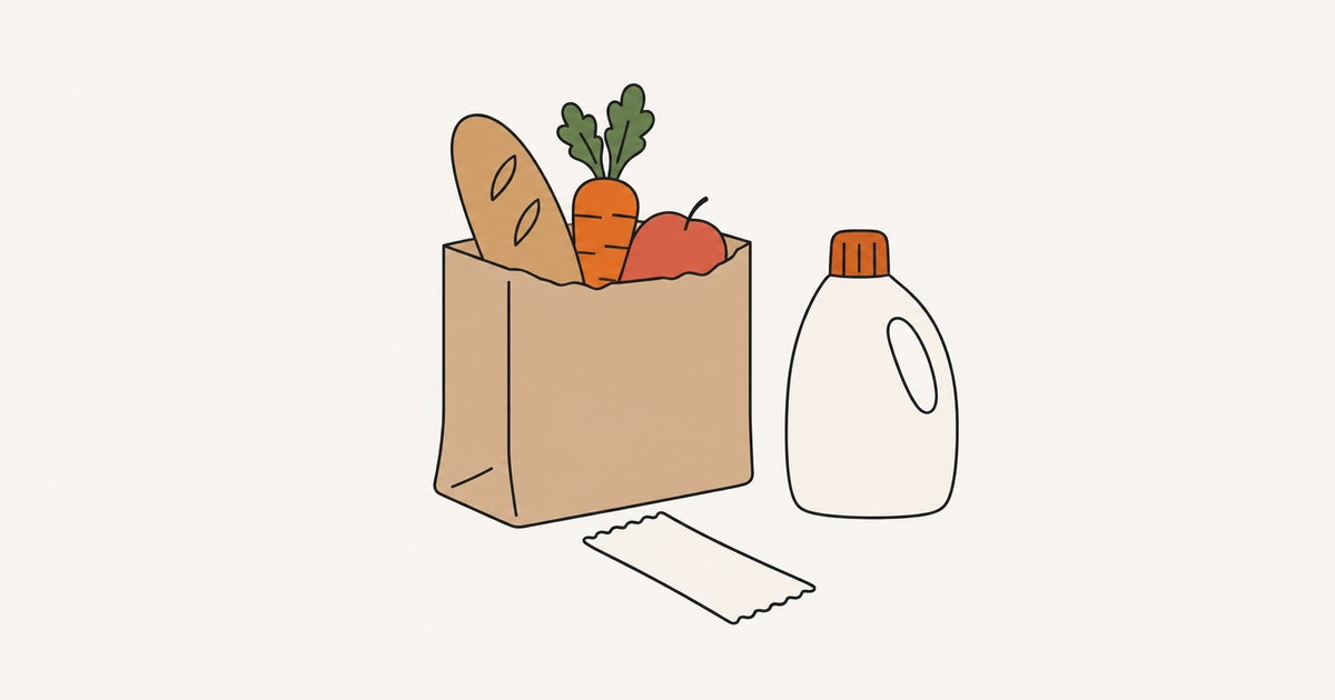 A grocery bag with bread, a carrot and fruit, beside a detergent bottle and a blank receipt.