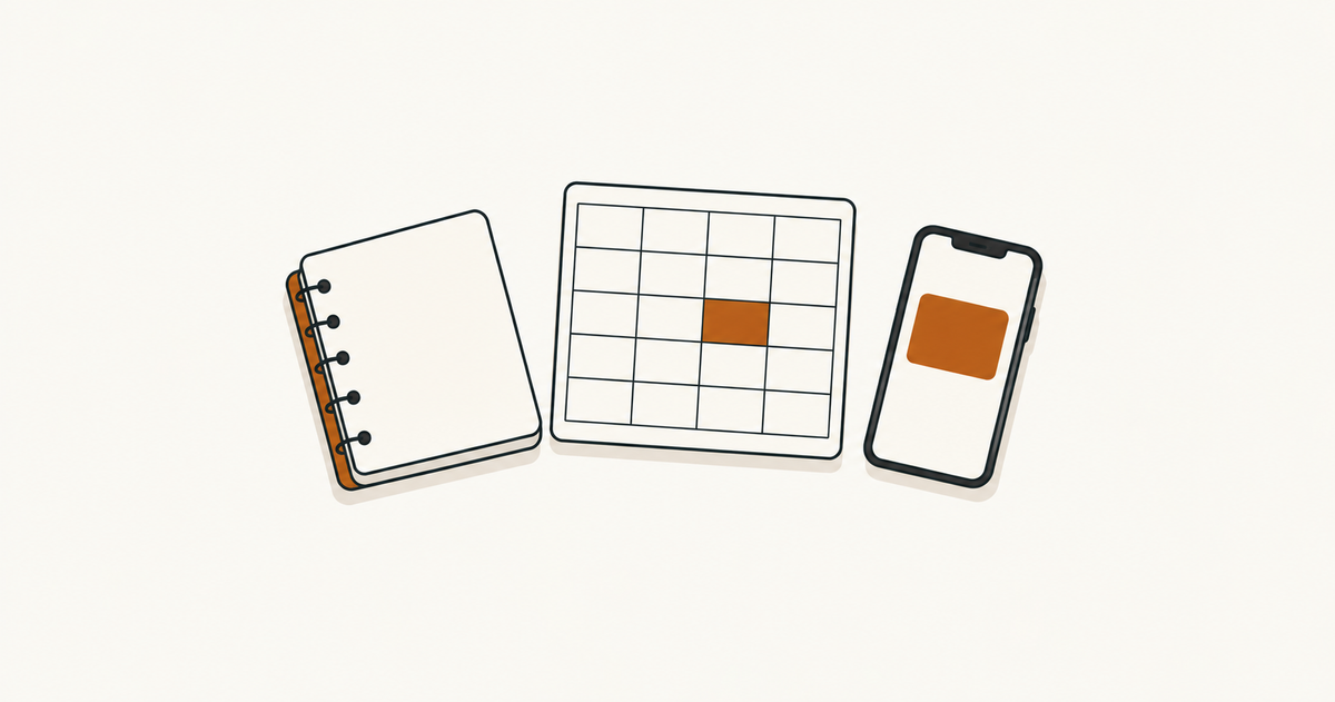 A closed notebook, a blank grid sheet and an upright phone with an orange rectangle on its screen.
