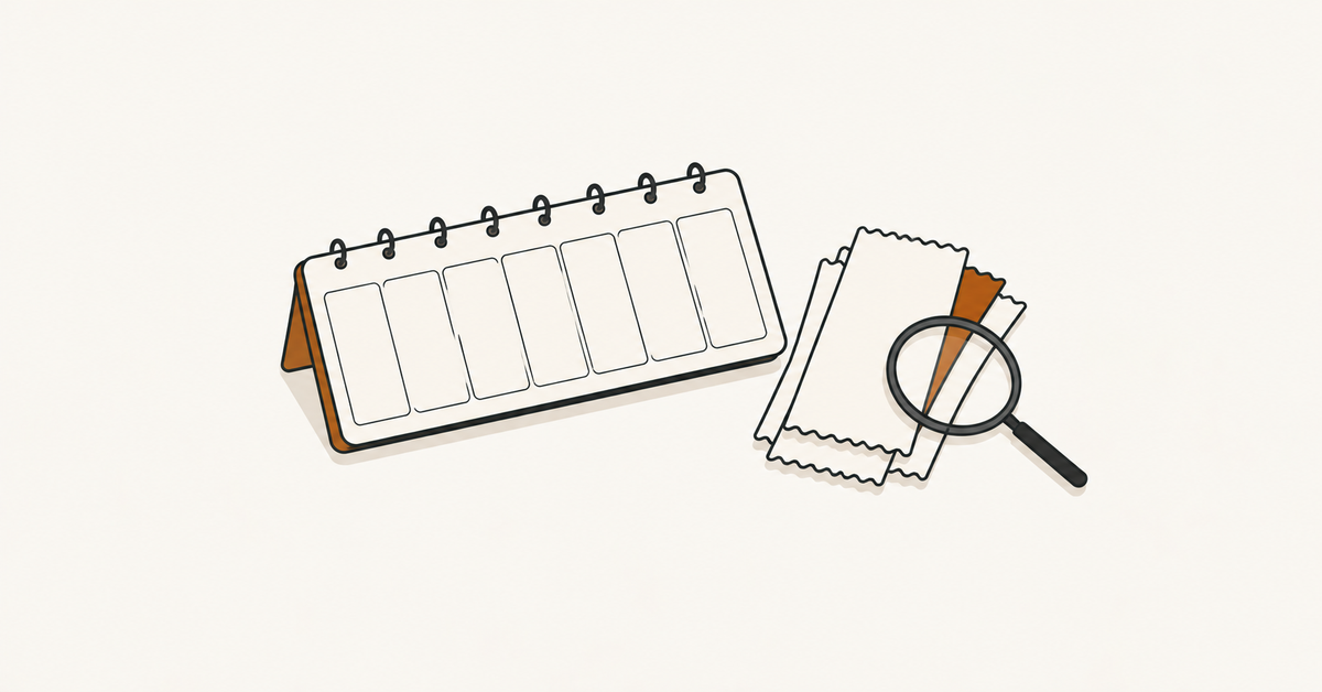A desk planner with blank cells beside stacked receipts, with a magnifying glass over the receipt edges.