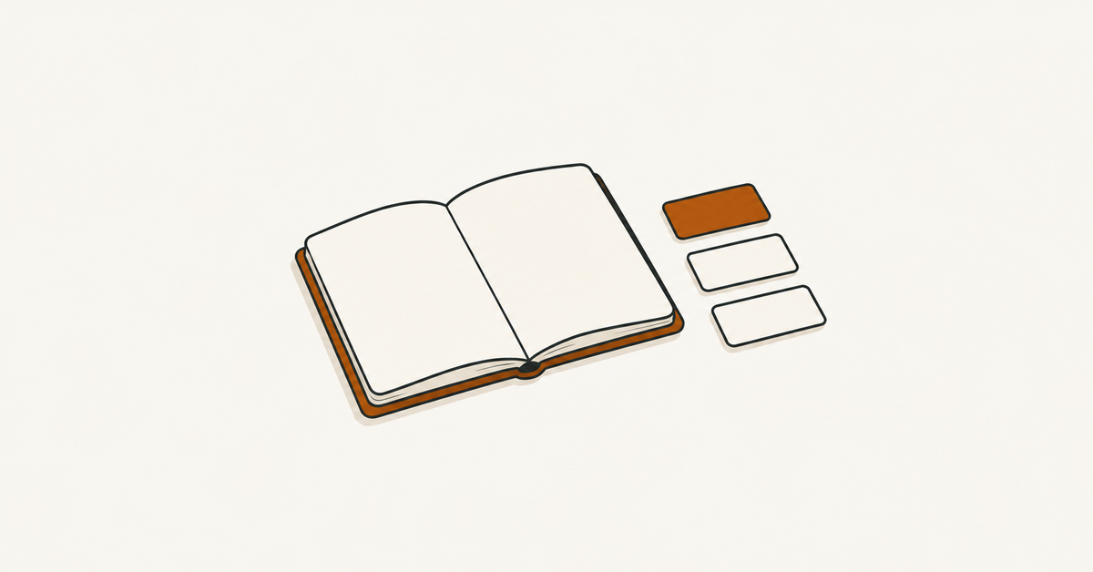 An open blank notebook beside small rectangular tiles, one orange and the others cream.