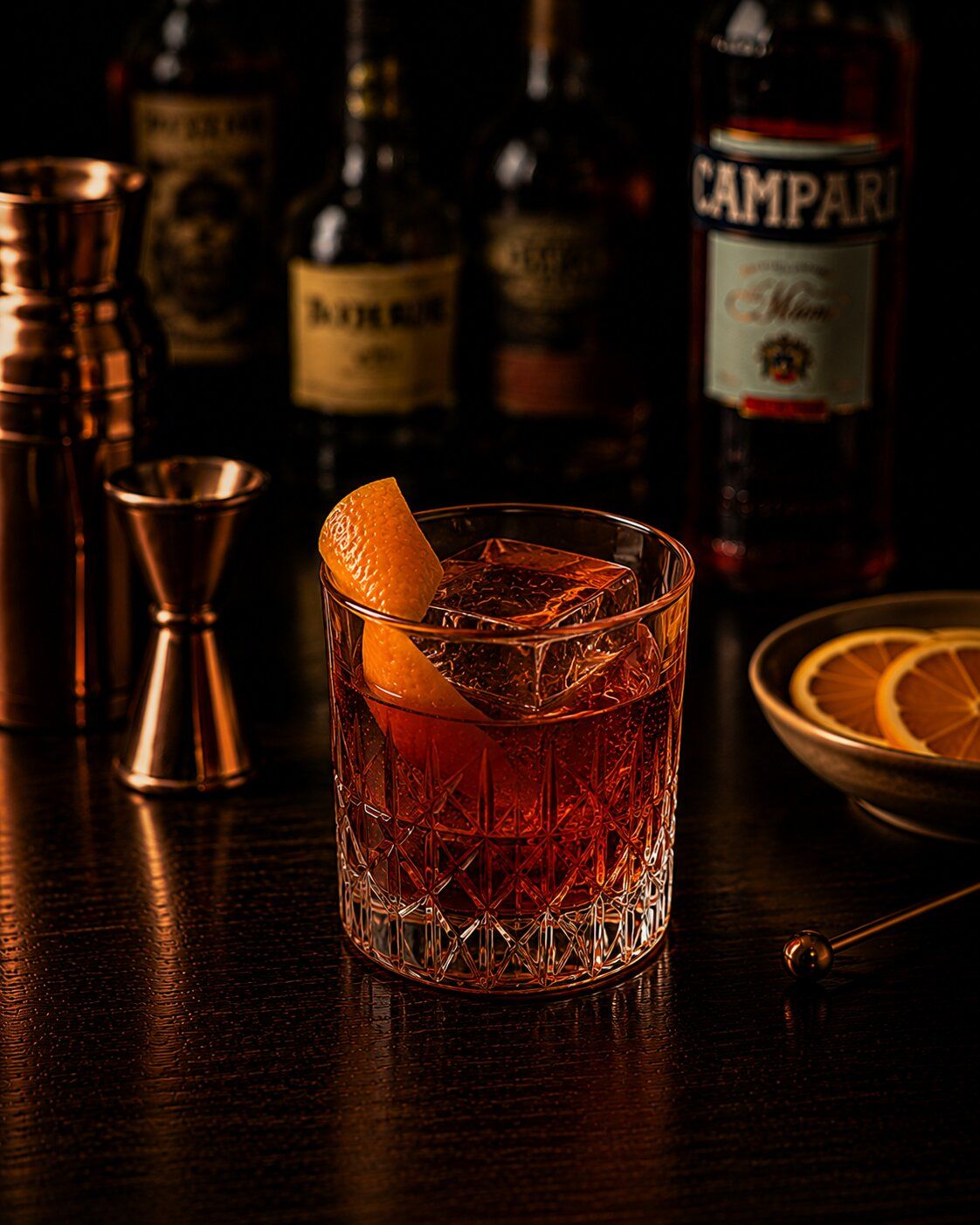 Boulevardier drink in rocks glass with orange wedge