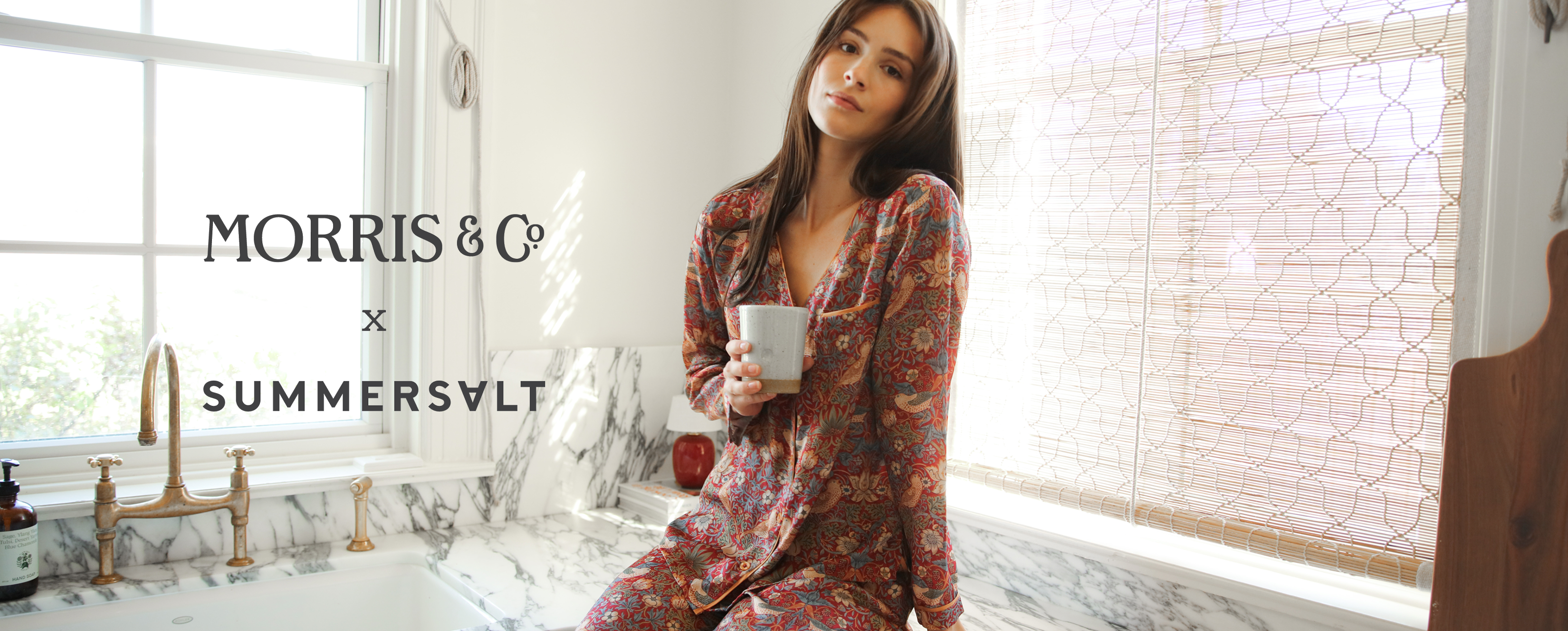Morris & Co x Summersalt. Model in The Silky Luxe Pajama Set Strawberry Thief in Crimson & Slate (red pattern)