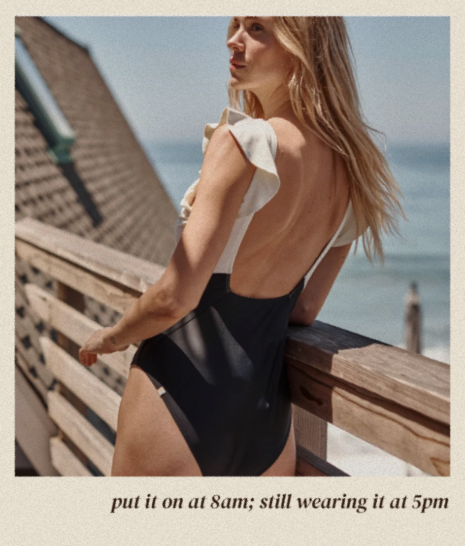 Model in black and white one piece swimsuit