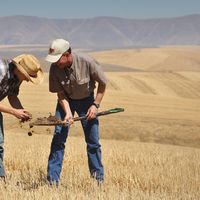 NRCS Soil Conservationist Garrett Duyck and farmer David Brewer examine a soil sample in a harvested field near The Dalles, Oregon.