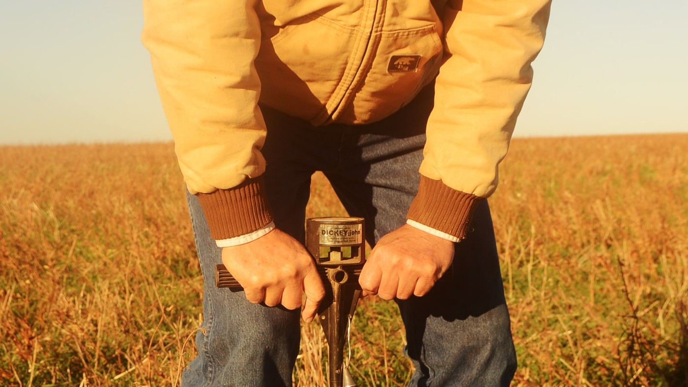 A Texas farmer pushes a soil pressure probe into a no-till dryland wheat field.