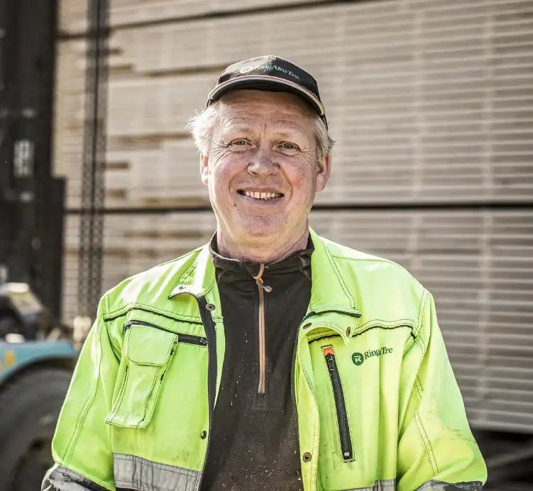 Ansatt foran stabler med trelast