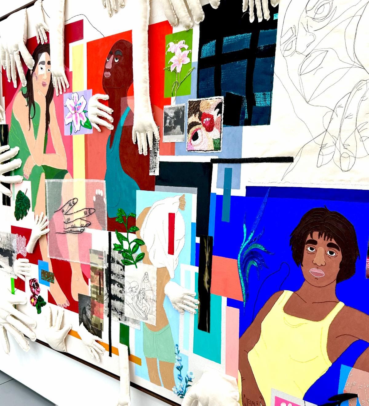 Textile collage crowded with stuffed-fabric hands reaching over stitched portraits, flowers, and bright color blocks.