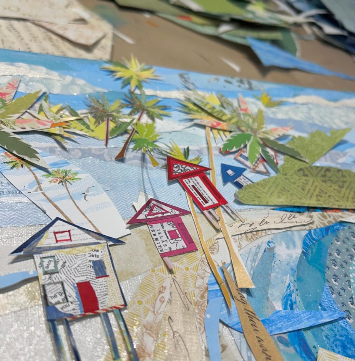 Detail of paper stilt cottages and hand-cut palm trees along the Sunny Days shoreline