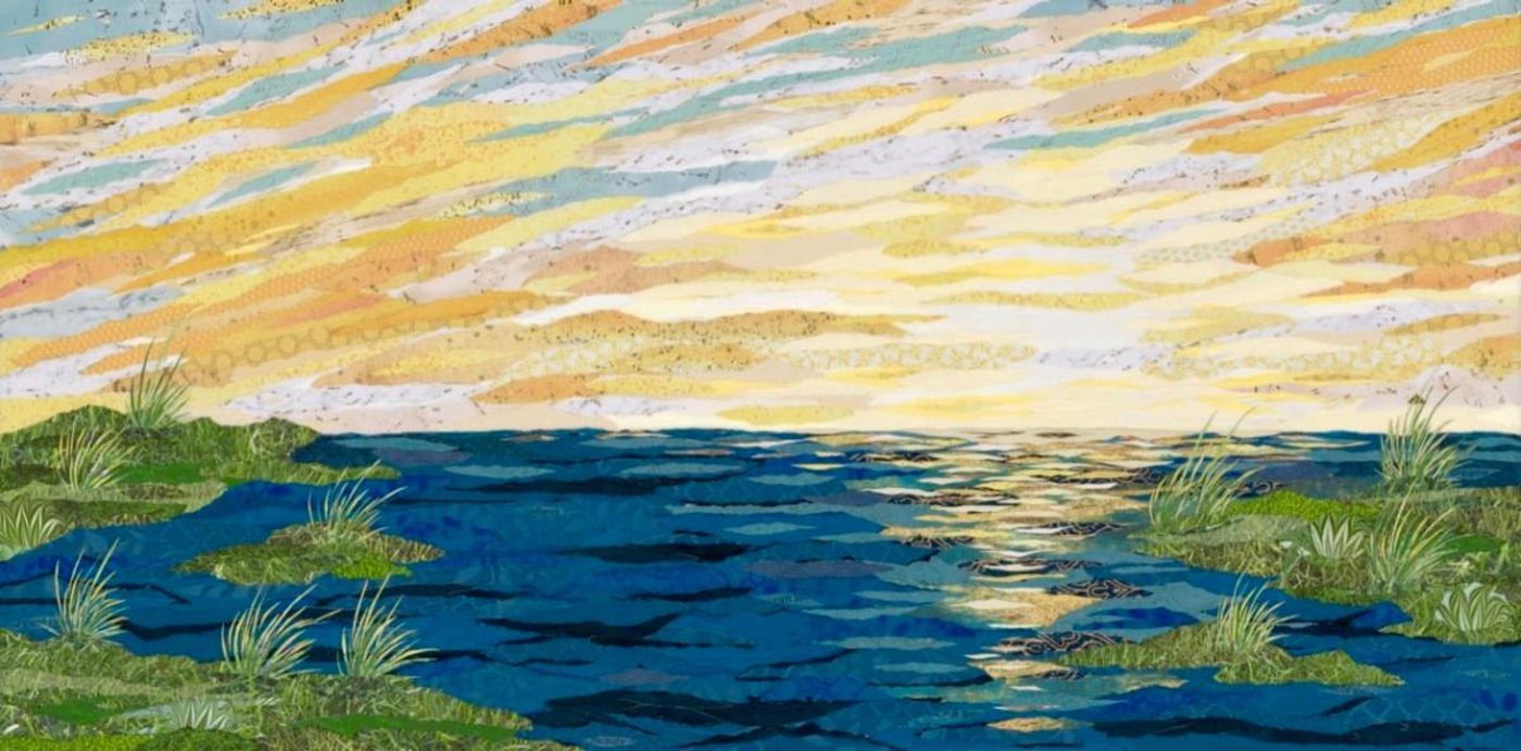 Layered paper collage of a bay at sunset — deep blue water with golden reflections, tall grasses on green banks, gold-streaked sky.
