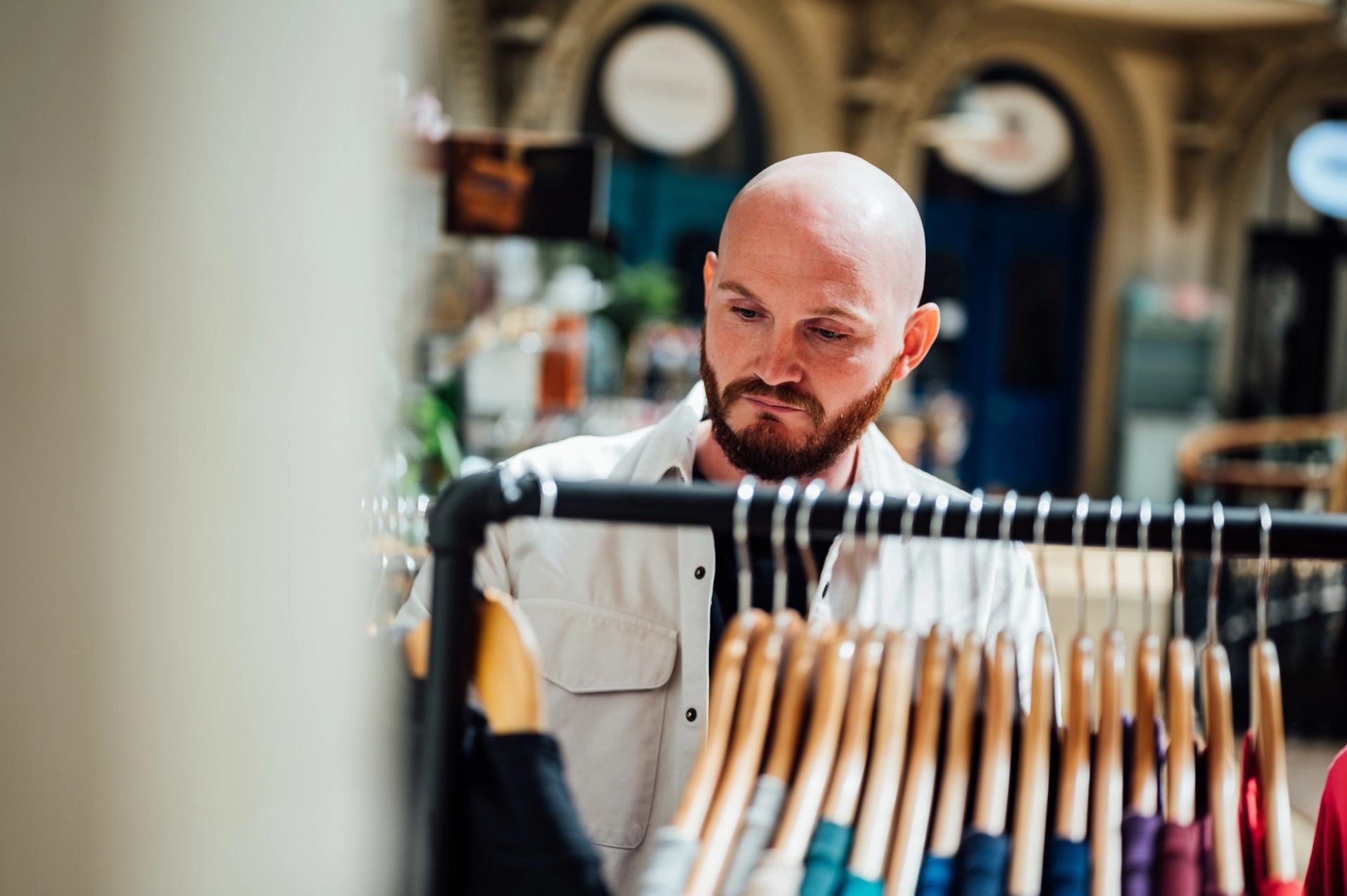 A shopper looking through a rail of clothes in a store