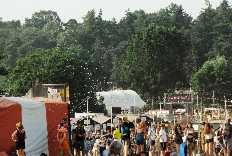 Visitors walking through an outdoor fall event in Nashville filled with vendor booths, drinks, and live performances.