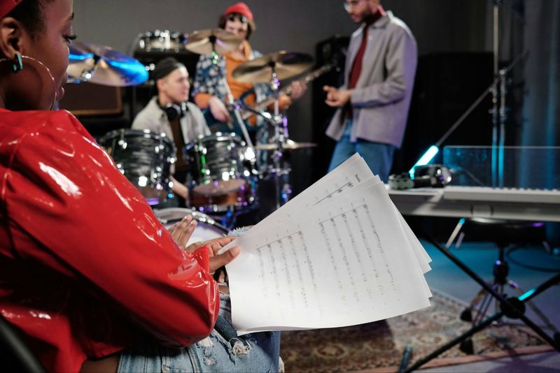 A female singer holding sheet music during band rehearsal as part of a music mentorship program in San Diego.