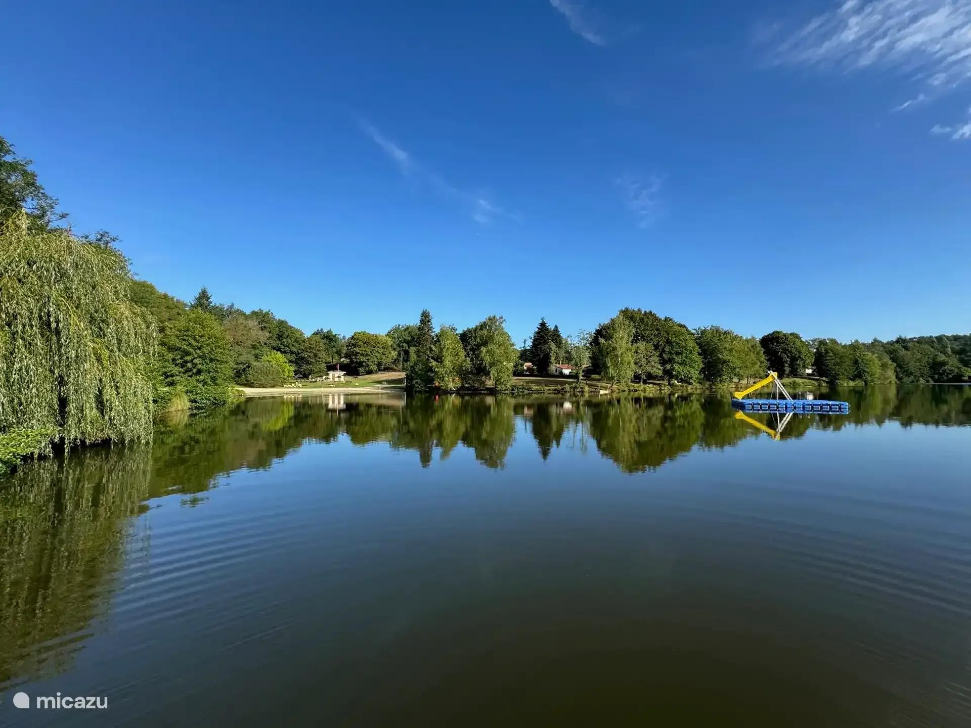 Het zwemmeer bij het park, met bomen langs de oever en een waterfiets