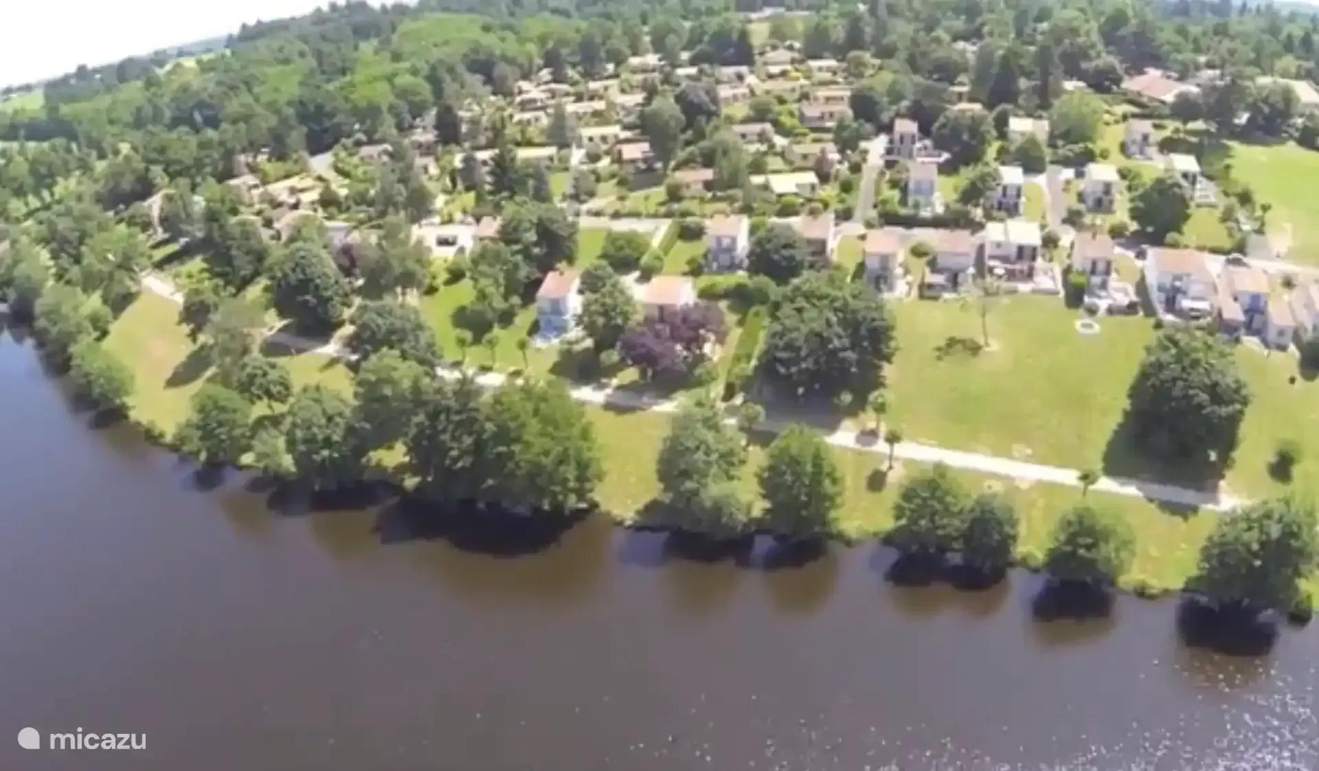 Luchtfoto van vakantiepark Village Le Chat, glooiend in het groen aan het zwemmeer