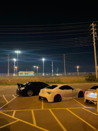 White and black coupes parked beside the railway after sunset