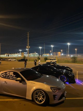 Silver and black coupes lined up under parking-lot lights