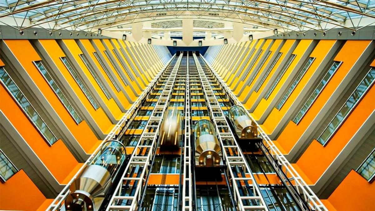 High-speed glass elevators operating inside a modern high-rise building atrium.