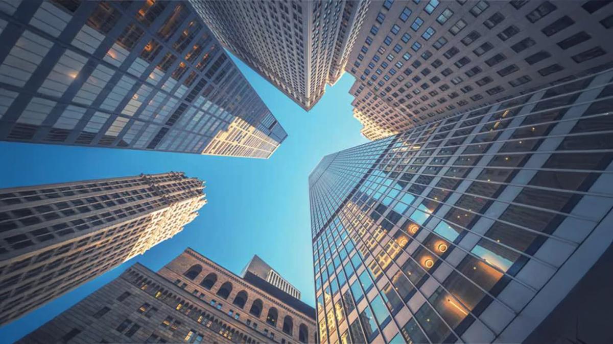 Upward view of tall commercial skyscrapers forming a modern urban skyline.