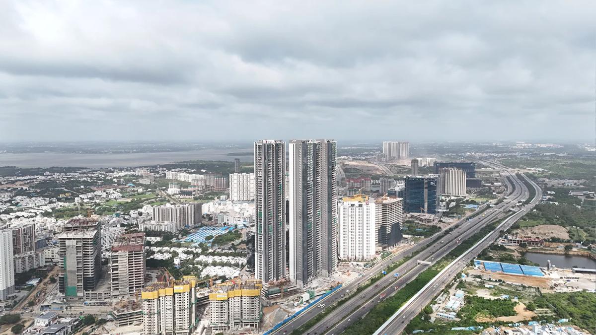 Aerial view of Kokapet with high-rise residential and commercial developments along a major highway in Hyderabad.