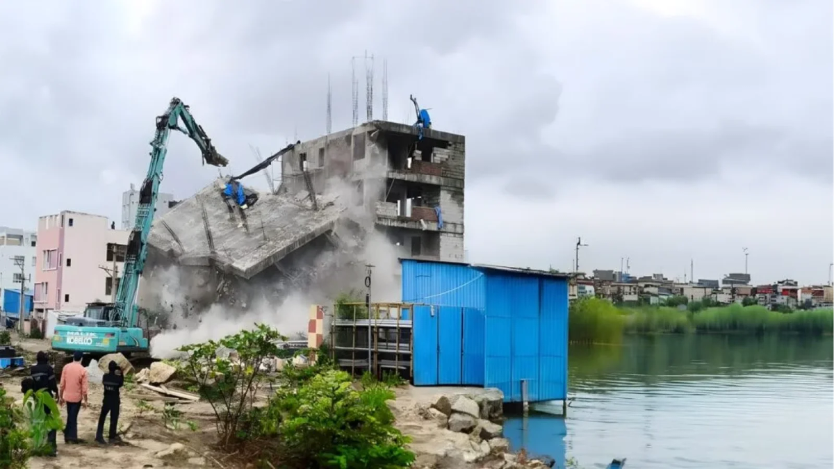 HYDRA demolition drive removing an illegal lakeside building in Hyderabad using heavy machinery.