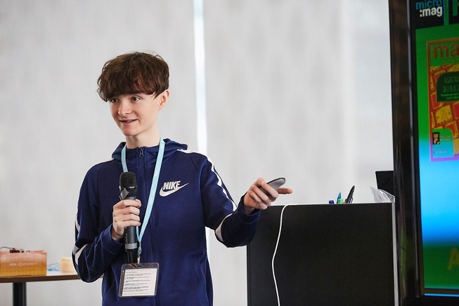 a boy giving a presentation in front of a screen