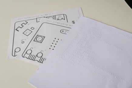 Printed tactile diagrams of the front and back of the micro:bit with a braille key