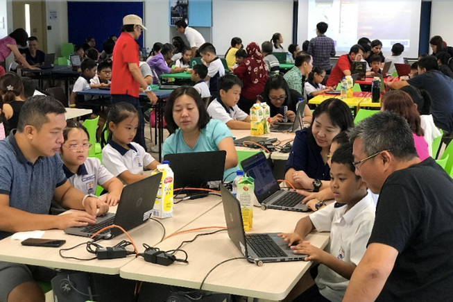 Parents and children working on laptops together