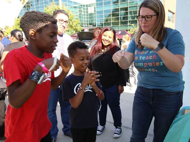 Two boys wearing micro:bits are mid-movement as they discover micro:bit CreateAI
