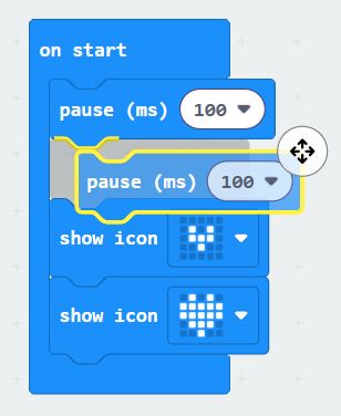 A MakeCode program with a pause block in move mode, ready to be moved by the arrow keys