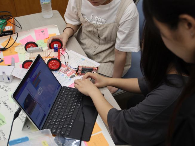 Some students connecting a micro:bit to accessories for their program.