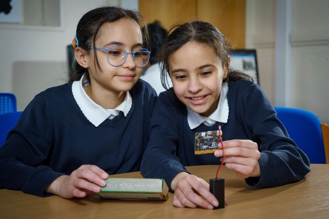 Two young girls engaging with a micro:bit