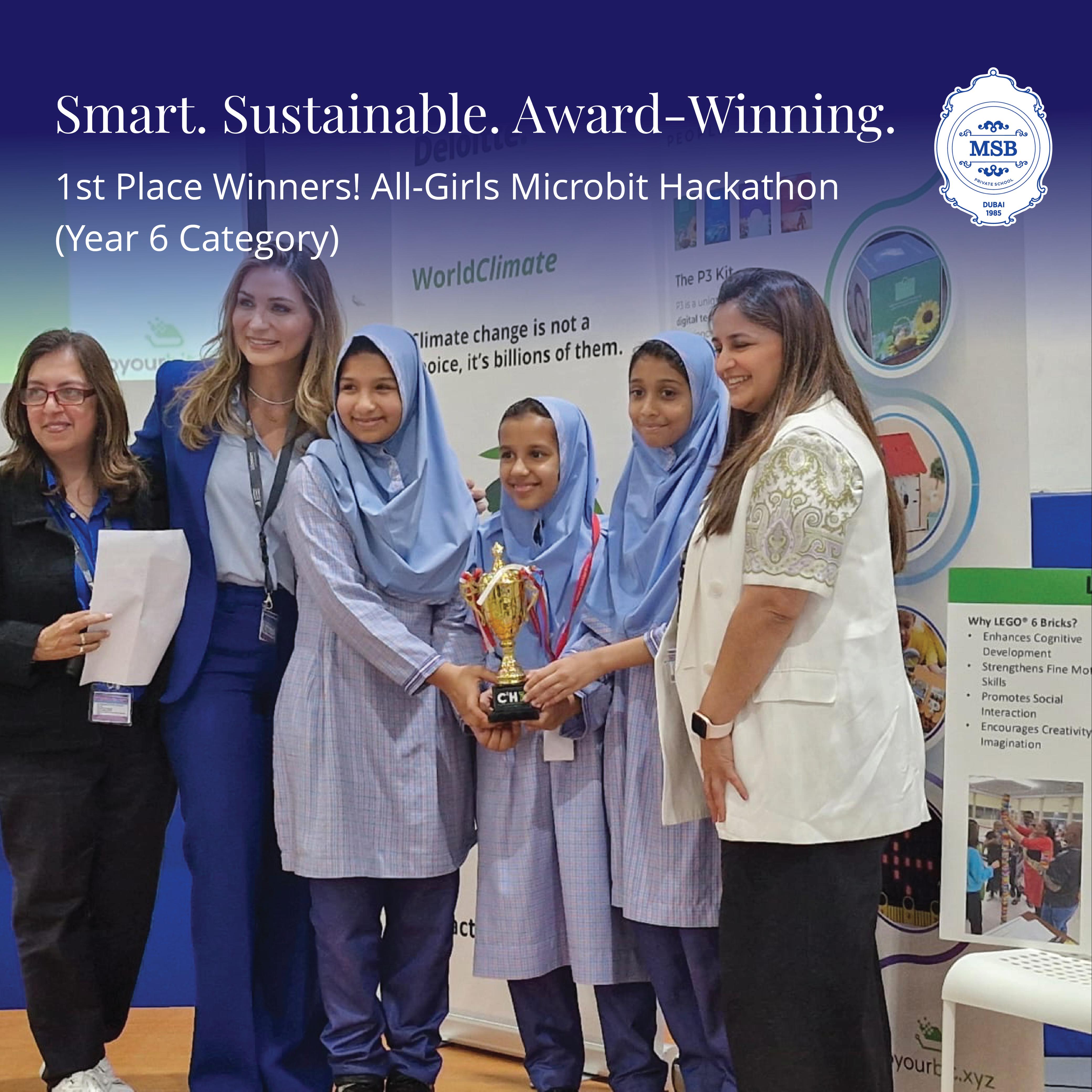 Students smile with their teachers holding an award for their project.