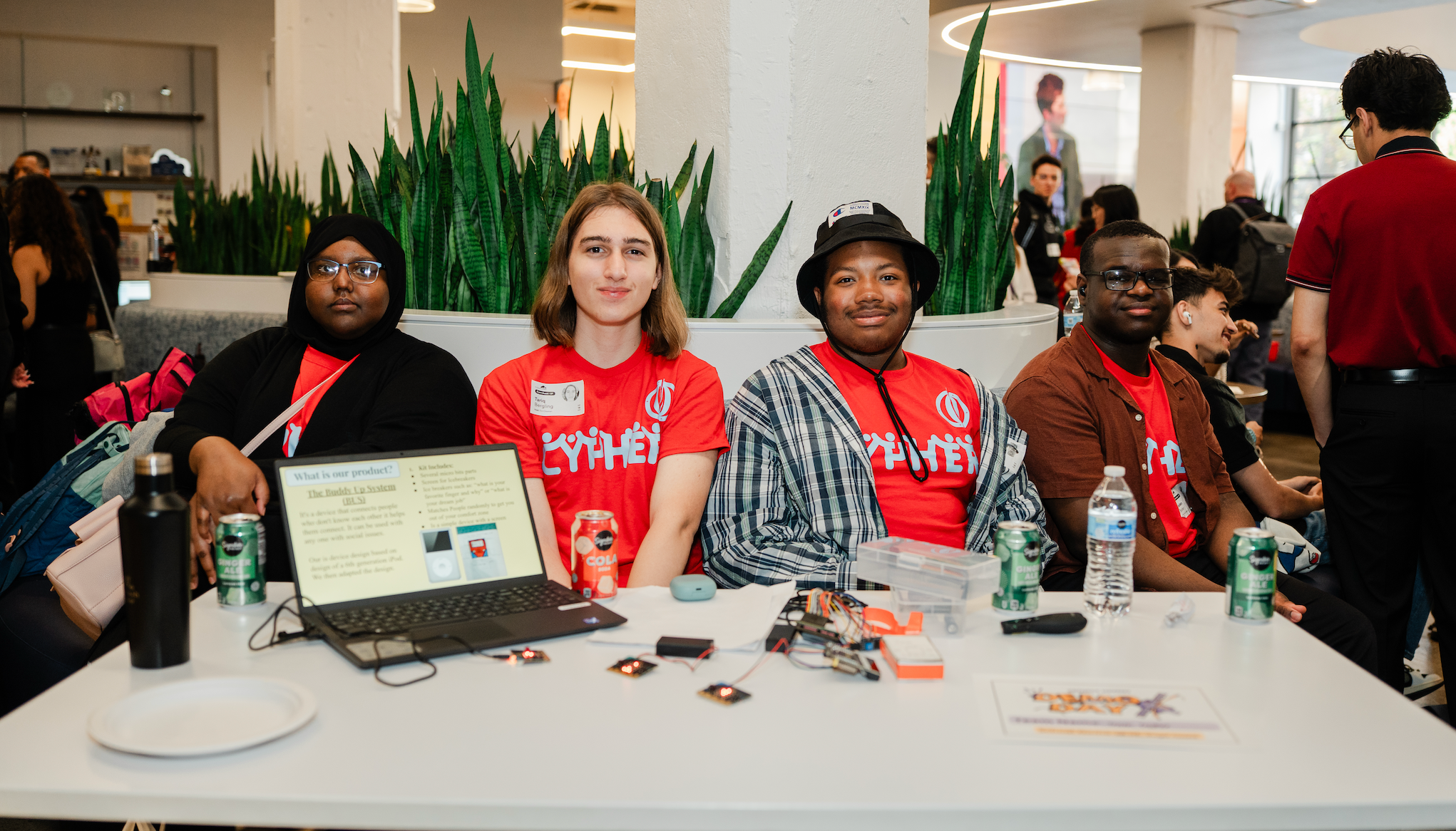 Students sit behind a table, demonstrating the Buddy Up System.