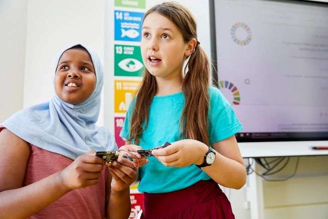 micro:bit にビックリした様子の 2 人の女の子