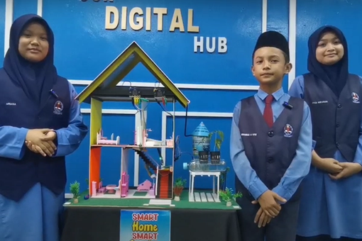 Three students from Malaysia stand in front of their "Smart Home, Smart Garden" project, created for do your :bit