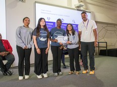 Students post in front of a screen after presenting their Equilibreans project.