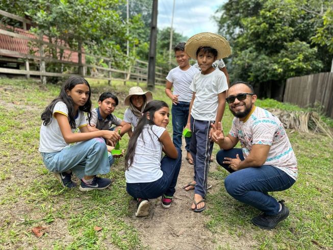 Group of children from the Amazon River Community pose for a photo with Tiago Cauassa, micro:bit Champion and community lead. 