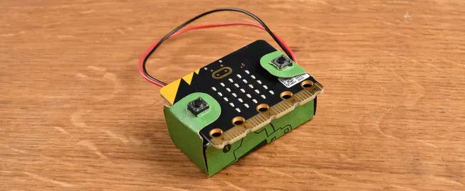 A micro:bit and battery pack attached to the cardboard battery pack holder.