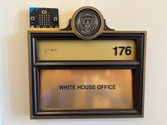 A micro:bit sits on top of a White House Office door plaque