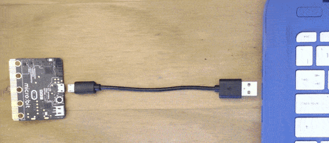 micro:bit board with LED blinking on its back as program is transferred to it