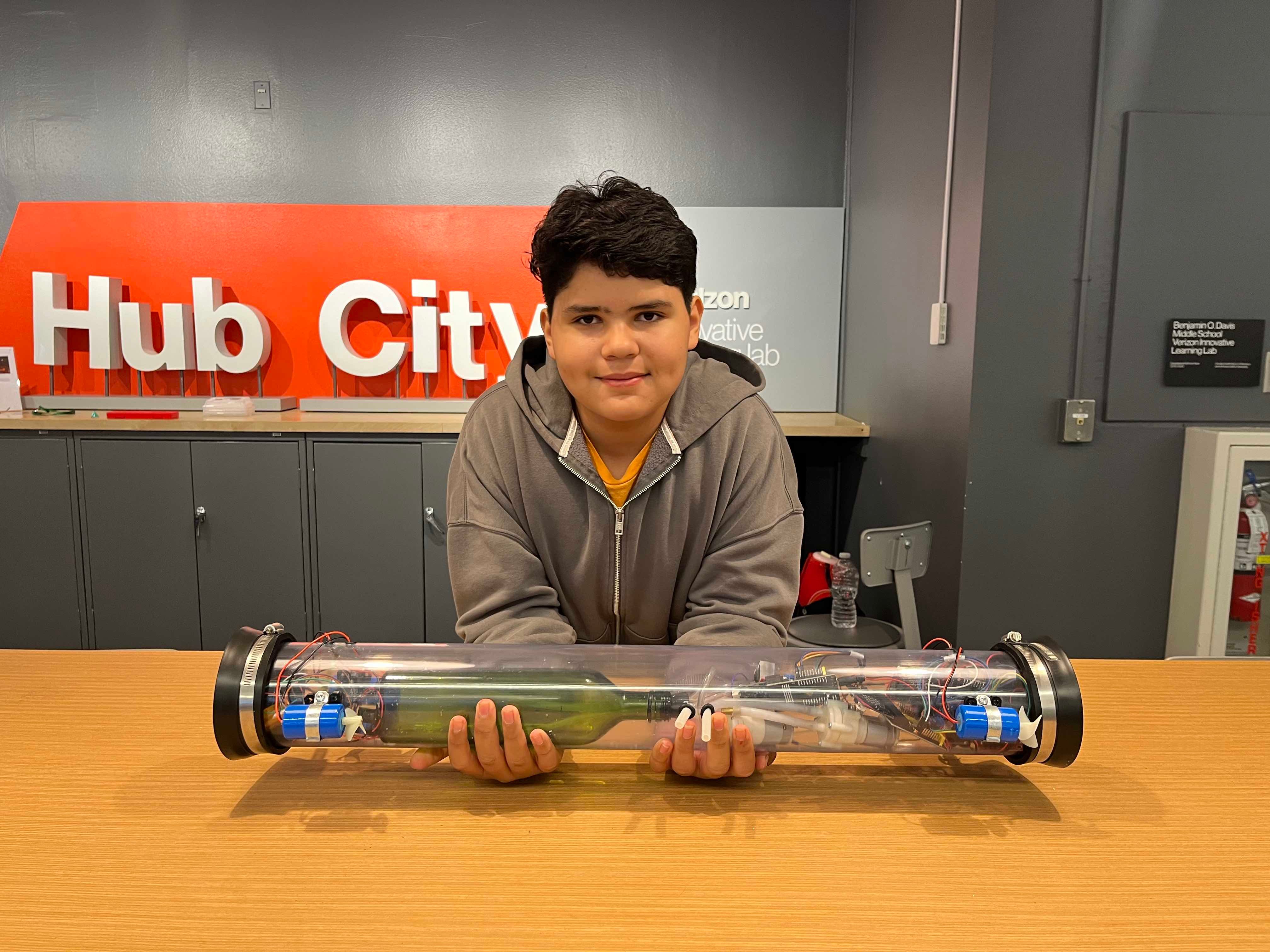 Student poses with the Micro Mini Submarine prototype.